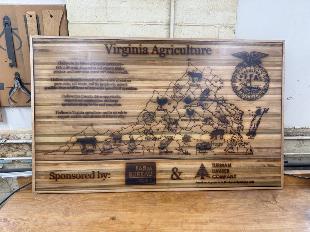 Large striped wooden wall sign with engraved Virginia agriculture artwork, a state map, FFA emblem, and sponsor branding.