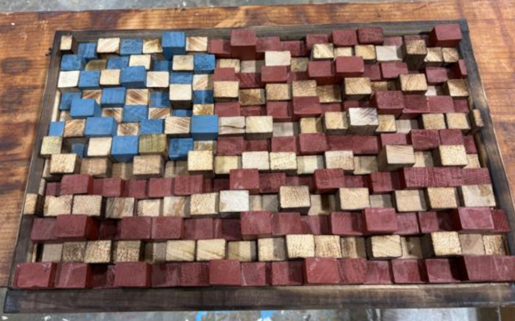 Wooden American flag artwork made from raised red, blue, and natural wood blocks.